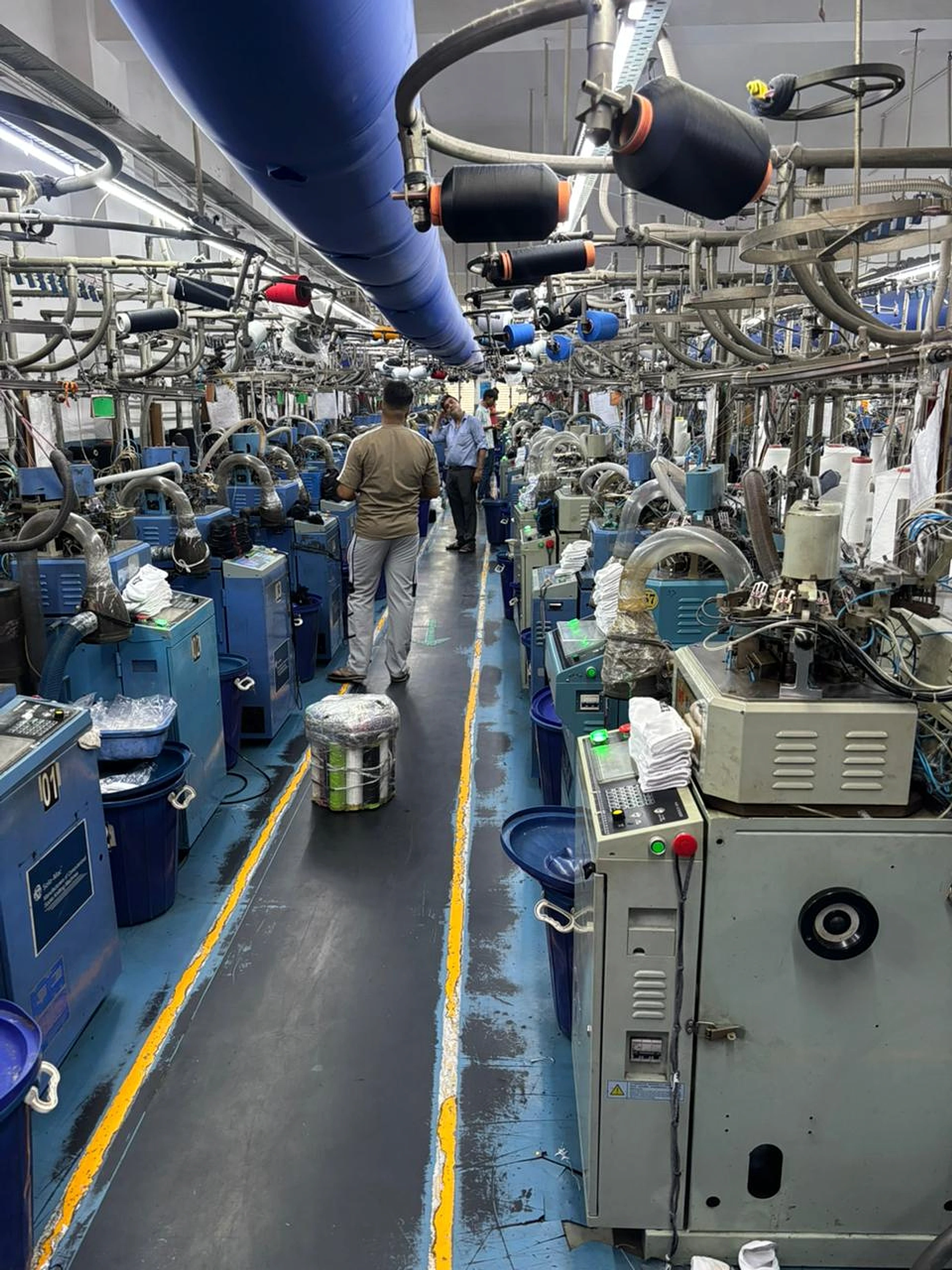 Circular sock knitting machines operating along the production floor