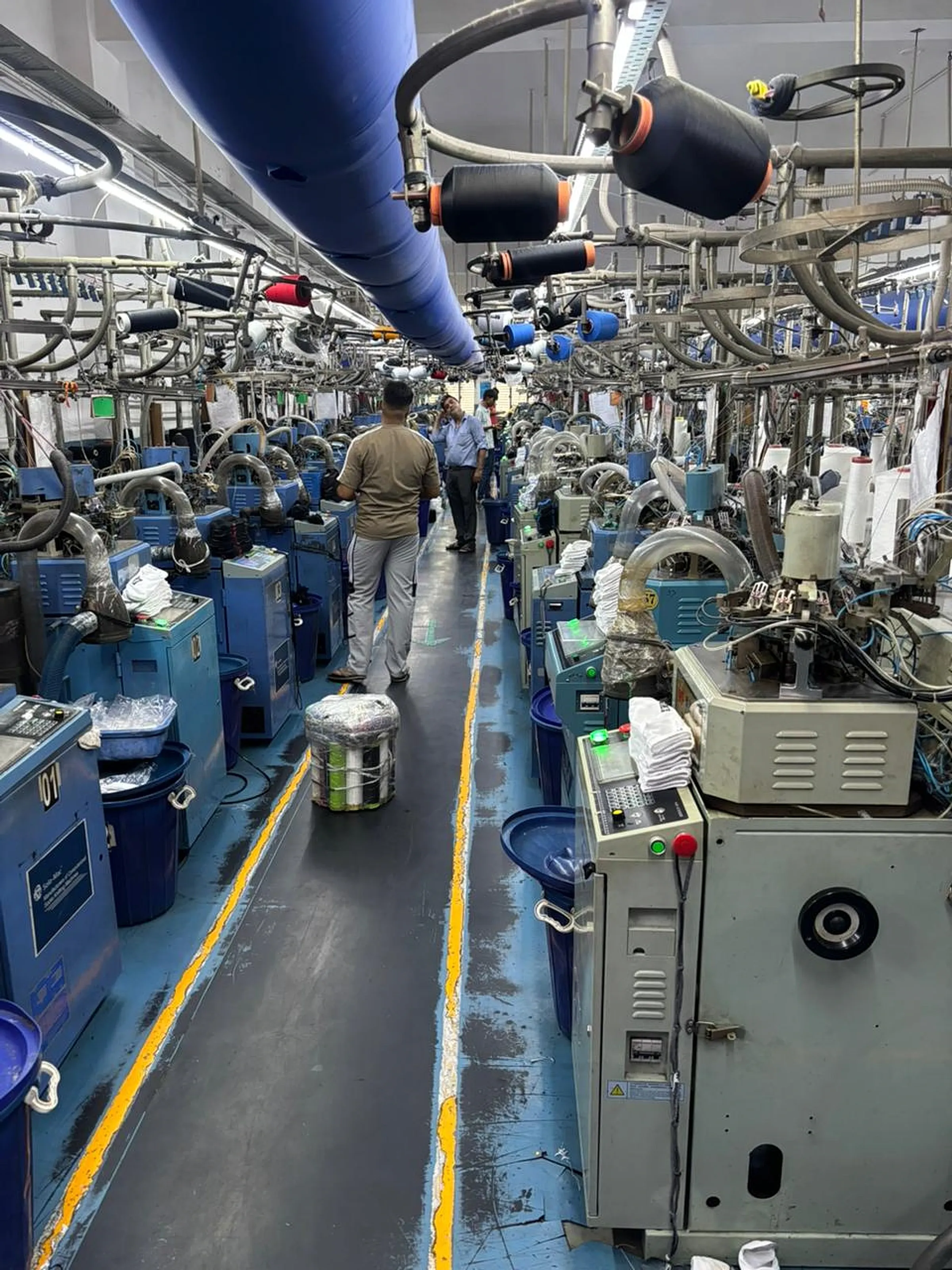 Circular sock knitting machines operating along the production floor